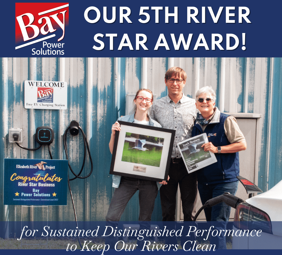 Representatives from Bay Power Solutions and The Elizabeth River Project standing in front of a Electrical Vehicle charging station with awards for Bay Power